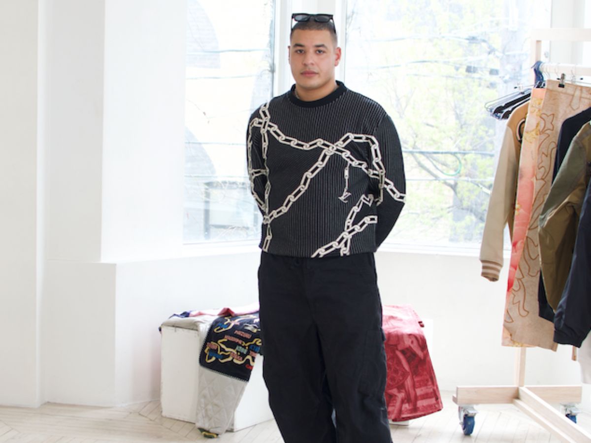 Man standing in well lite room with clothes laying around